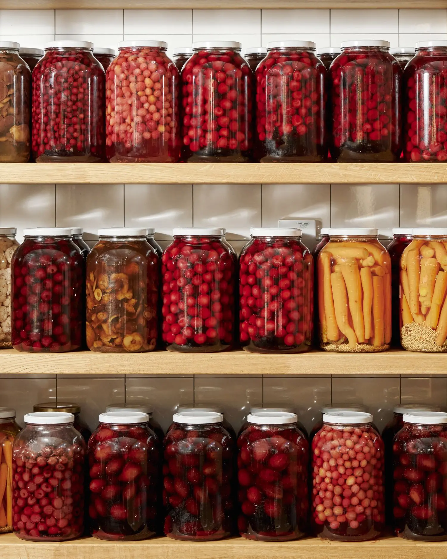 Shelves with homemade preserves and pickled vegetables at Čestr restaurant.